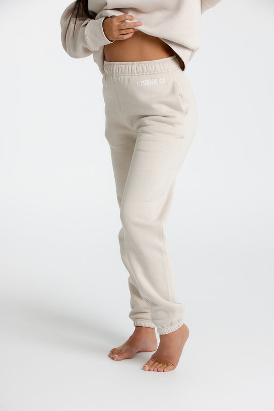 Woman wearing creamy tan trackpants from our Soft Touch Collection, showcasing a cozy and stylish winter look.