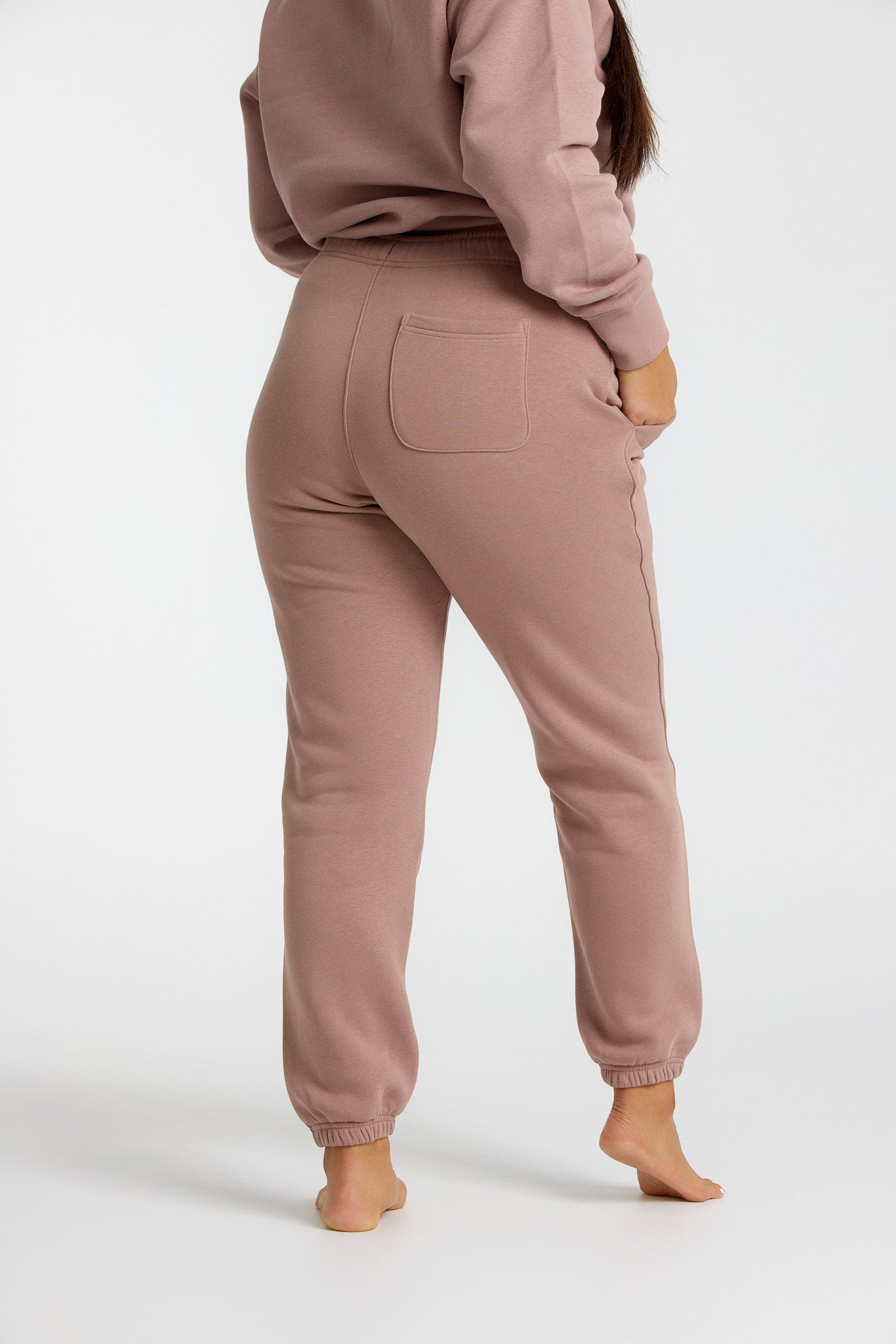 Woman wearing cocoa blush trackpants from our Soft Touch Collection, showcasing a cozy and stylish winter look.